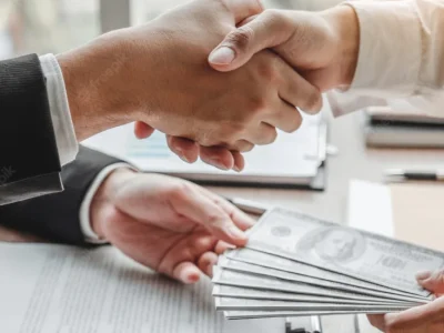 businessman-shaking-hands-giving-dollar-bills-corruption-bribery-business-manager-deal-contract_45041-198-1110x550
