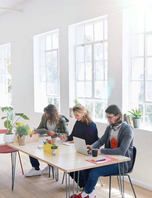 College students sitting at table in class working on project.